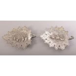 TWO INDIAN KUTCH SILVER LEAF FORM DISHES, the centre of each with embossed and finely chased scenes;