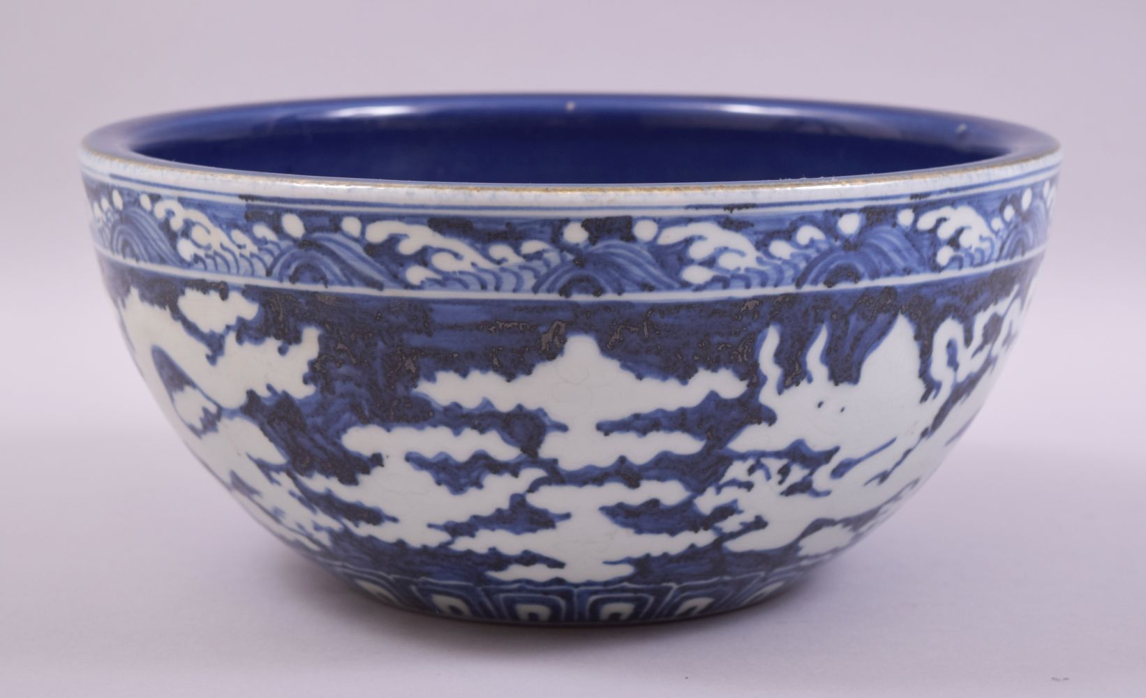 A LARGE CHINESE SACRIFICIAL BLUE GLAZE DRAGON BOWL, the exterior with white dragons and clouds