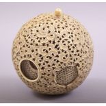 A CARVED AND PIERCED IVORY PUZZLE BALL, profusely pierced and carved with foliate design, approx.