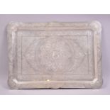 A PERSIAN WHITE METAL TRAY, of shaped rectangular form, profusely engraved with floral design,