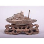 A SMALL CHINESE FILIGREE MODEL OF A JUNK, on a wooden stand, 7.5cm long.