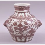 A CHINESE IRON RED AND WHITE GLAZED POTTERY VASE, with moulded handles and painted with native flora
