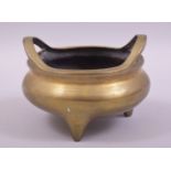 A GOOD CHINESE BRASS TWIN HANDLE TRIPOD CENSER, the base with mark, 14cm diameter.