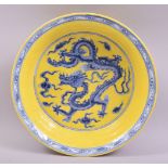 A CHINESE YELLOW GROUND PORCELAIN DRAGON BOWL, the centre painted with a dragon in blue with