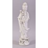 A CHINESE PORCELAIN BLANC DE CHINE FIGURE OF GUANYIN, stood upon a lotus base, 30.5cm high.
