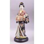 A JAPANESE KUTANI PORCELAIN FIGURE, modelled as a standing geisha and mounted on a wooden base, 42cm