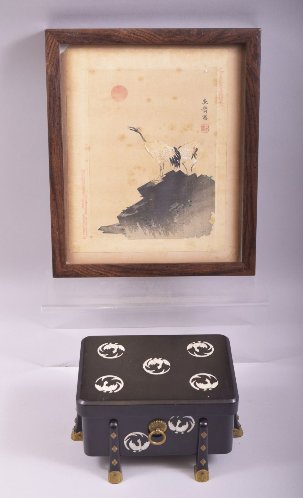 A JAPANESE BLACK LACQUER AND MOTHER OF PEARL INLAID BOX AND COVER, supported on eight feet with