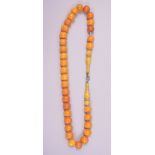A FINE SET OF CHINESE OR ISLAMIC AMBER BEADS, comprising 33 spherical beads; each approx. 12mm,