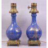 A PAIR OF CHINESE BLUE GROUND AND GILT DECORATED PORCELAIN LAMPS / VASES with ormolu mounts, the