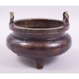 A CHINESE BRONZE TWIN HANDLE TRIPOD CENSER, with rope form handles, the rim with six character