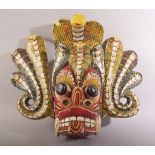 A LARGE SRI LANKAN CARVED AND PAINTED WOODEN MASK, 33cm x 45cm.