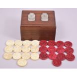 A SET OF FOURTEEN STAINED RED IVORY COUNTERS, and thirteen white counters, 4cm diameter, carved with