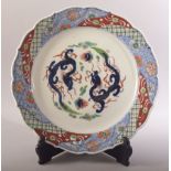 A LARGE JAPANESE PORCELAIN DISH AND STAND, decorated in the imari palette and with dragons to