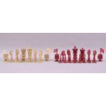 A 19TH CENTURY BURMESE STAINED RED AND WHITE IVORY CHESS SET, king 8cm, queen 7.5cm.