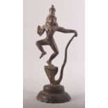 AN INDIAN BRONZE FIGURE OF A DEITY, stood upon a multi headed snake, possibly Vishnu stood upon