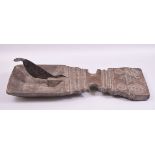 A LARGE 18TH/19TH CENTURY CARVED WOODEN COCONUT CUTTER TRAY, overall measuring 63cm long.