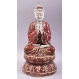 A CHINESE DEHUA COPPER RED GLAZE FIGURE OF GUANYIN, seated upon a lotus base, with marks to the