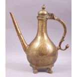 AN 18TH CENTURY MUGHAL BRASS EWER, raised on four brass feet, 33cm high.