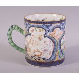 A CHINESE CLOBBERED PORCELAIN MUG / TANKARD, painted with three panels depicting outdoor settings