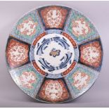 A LARGE JAPANESE IMARI PORCELAIN CHARGER, painted with floral panels in the imari pallette, the