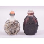 TWO CHINESE SNUFF BOTTLES, one opaque glass with coral stopper, the other amethyst glass (lacking
