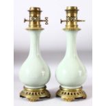 A PAIR OF CELADON PORCELAIN VASES CONVERTED TO LAMPS with brass mounts, 40cm high.