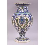 A TURKISH OTTOMAN KUTAHYA GLAZED POTTERY VASE, painted with sprays of stylised flora, 31.5cm high.