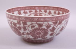 A CHINESE UNDERGLAZED RED PORCELAIN BOWL, the bowl decorated with large flower heads and vine with a