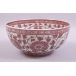 A CHINESE UNDERGLAZED RED PORCELAIN BOWL, the bowl decorated with large flower heads and vine with a