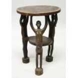 AN UNUSUAL AFRICAN HARDWOOD STOOL, the circular top supported by three figures with arms