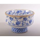 A TURKISH IZNIK BLUE AND WHITE GLAZED POTTERY PEDESTAL BOWL, painted with scrolling foliate
