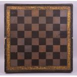 A CHINESE LACQUER AND GILT FOLDING CHESS BOARD, the interior with a backgammon board, 50cm wide.