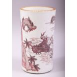 A CHINESE UNDER GLAZED RED PORCELAIN BRUSH POT, painted with figures and a dragon in a lake scene,