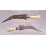 TWO 18TH/19TH CENTURY MUGHAL INDIAN DAGGERS, both with two piece bone handles, one with leather