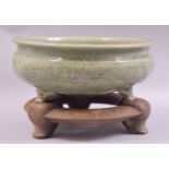 A VERY GOOD LARGE CHINESE CELADON GLAZED TRIPOD BOWL AND STAND, with incised foliate decoration to