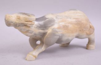 A CHINESE HARDSTONE OR WHITE JADE CARVING OF A BUFFALO, 23cm long.