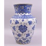 A LARGE TURKISH IZNIK BLUE AND WHITE POTTERY VASE, painted with stylised flower heads, 31cm high.