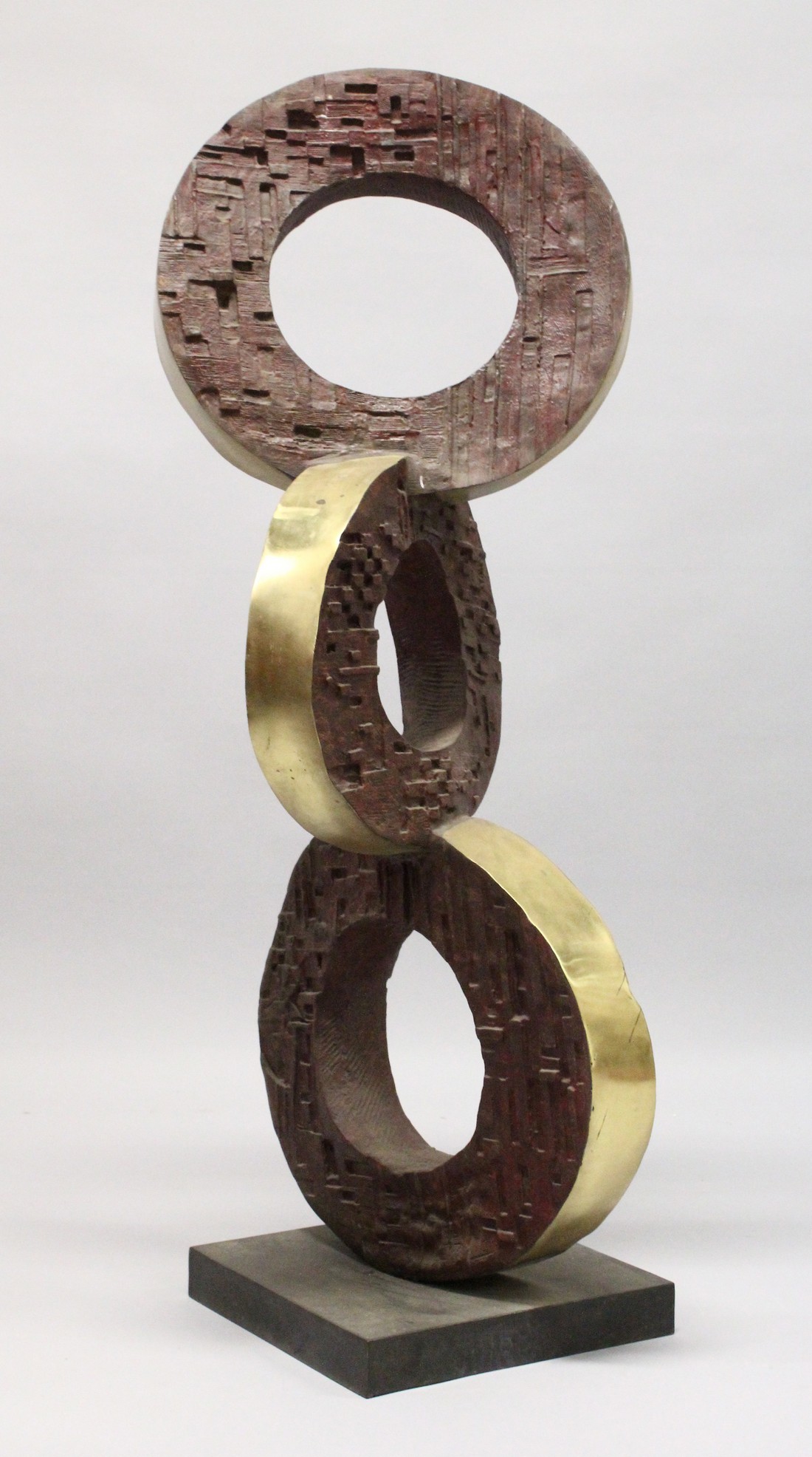 A LARGE BRONZE ABSTRACT MODEL, three rings on a square base. 4ft high.