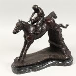 A BRONZE HORSE AND JOCKEY jumping over a fence, 12ins high on a marble base.