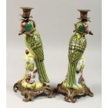 A GOOD PAIR OF PORCELAIN PARROT CANDLESTICKS, 15ins high.