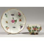 A SMALL MEISSEN FLOWER ENCRUSTED CUP AND SAUCER, painted with butterflies. Cross sword mark in
