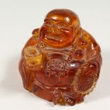 AN AMBER BUDDHA 4.5ins high.