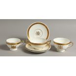 TWO MINTON CUPS of different design and three matching saucers, gilded with the Coat of Arms of