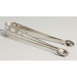 TWO GEORGE III BRIGHT CUT SUGAR TONGS, Circa.1800, maker T T & maker R C