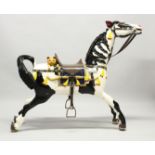 A PERIOD CARVED WOOD RE-PAINTED FAIRGROUND HORSE, a carved cat on its back. 3ft 9ins long, 3ft