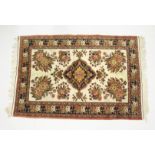 A PERSIAN RUG, cream ground with large floral decoration. 6ft x 4ft 1ins.