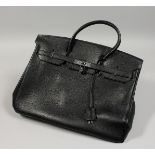 A LARGE BLACK LEATHER BAG with chrome lock and dust cover. 17ins long.