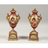 A VERY GOOD PAIR OF 19TH CENTURY VIENNA PORCELAIN TWO HANDLED URNS AND COVERS painted with portraits