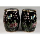A PAIR OF BLACK CHINESE PORCELAIN BARREL SEATS with flowers and birds. 17.5ins high.