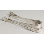 TWO GEORGE III BRIGHT CUT SUGAR TONGS, S A London 1784.